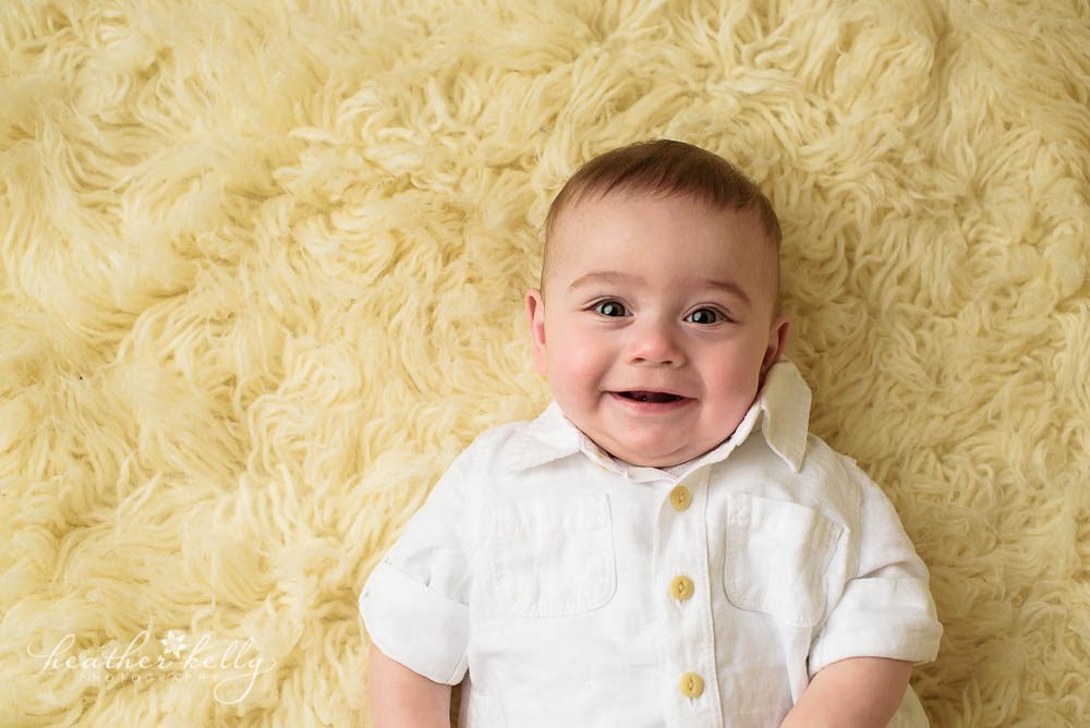 smiling 6 month boy on flokati rug