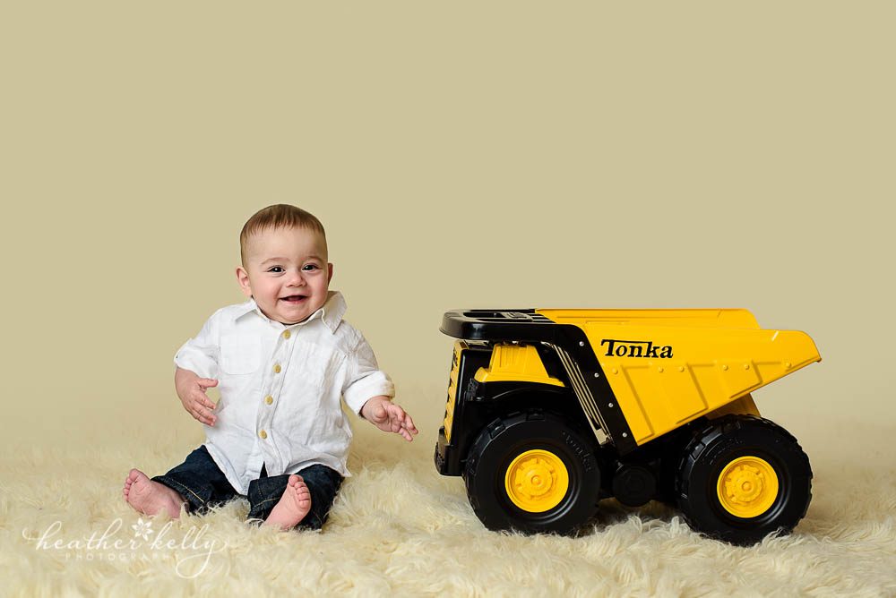 6 month boy sitting next to tonka truck at photography session