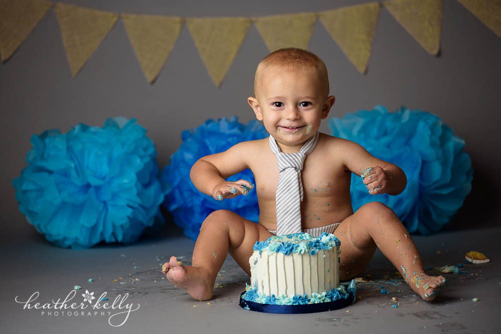 gray background cake smash with white and blue cake