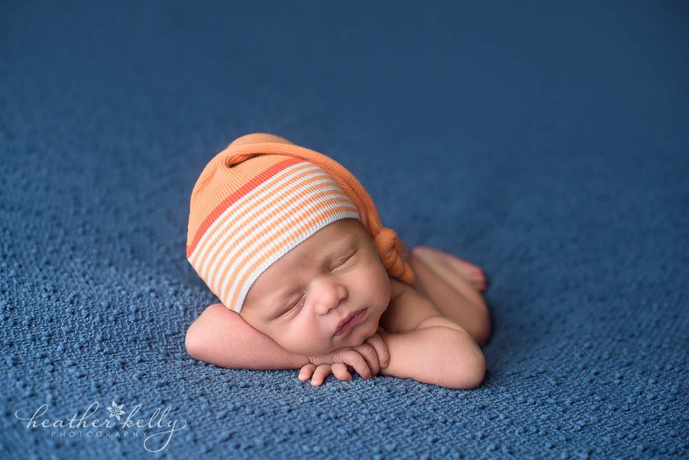 newborn boy in orange sleepy cap
