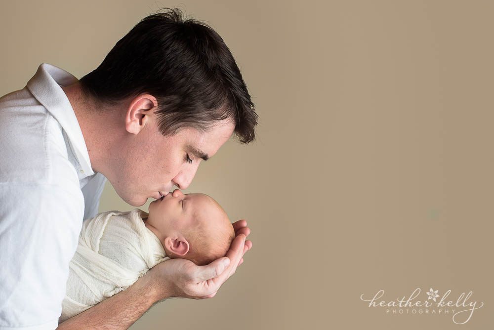 newborn photography dad kissing newborn