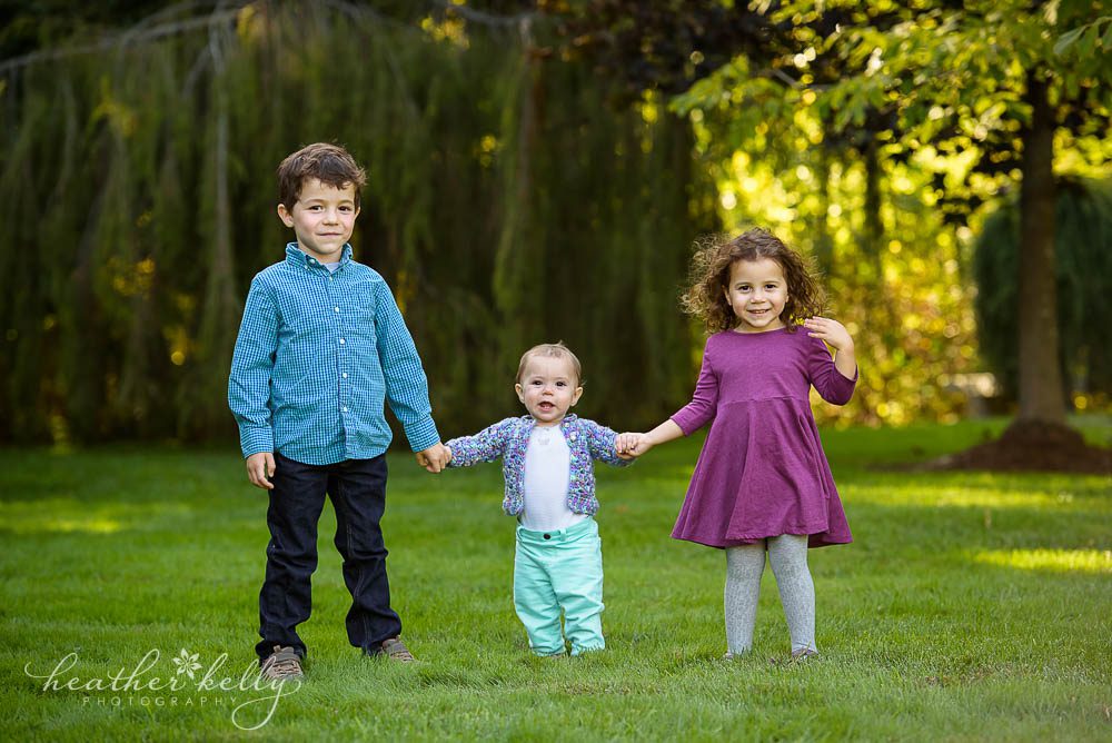 family photography three kids standing and holding hands