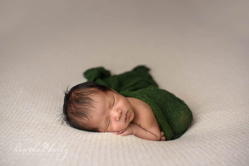 newborn boy with dark green wrap photo