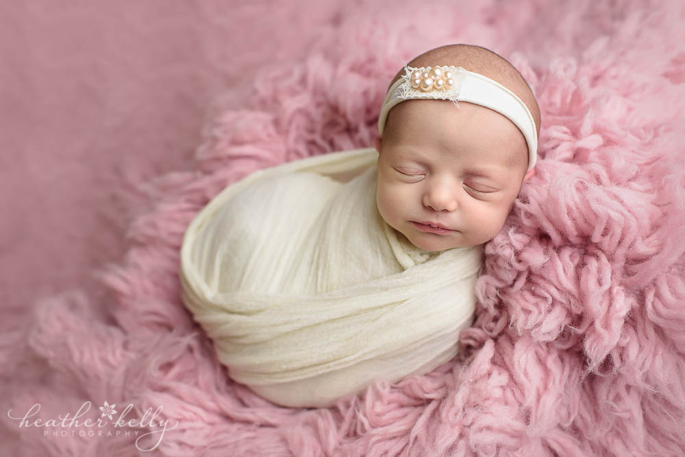 Pink and white newborn photography with baby girl wrapped in white. Adorable Monroe newborn. 