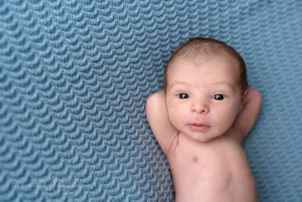 image of baby boy relaxing on blue blanket ct newborn photographers