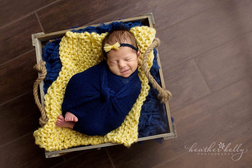 newborn in square crate. yellow and navy blue. newtown ct twins