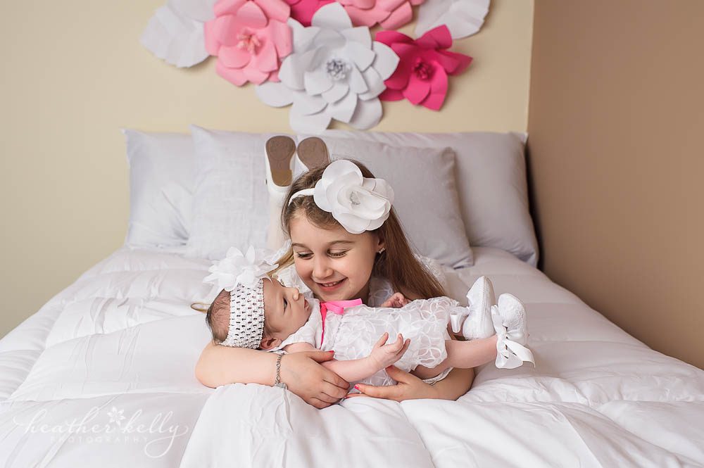 ct newborn photographer | big sister hold baby girl on bed photo | newtown newborn photos