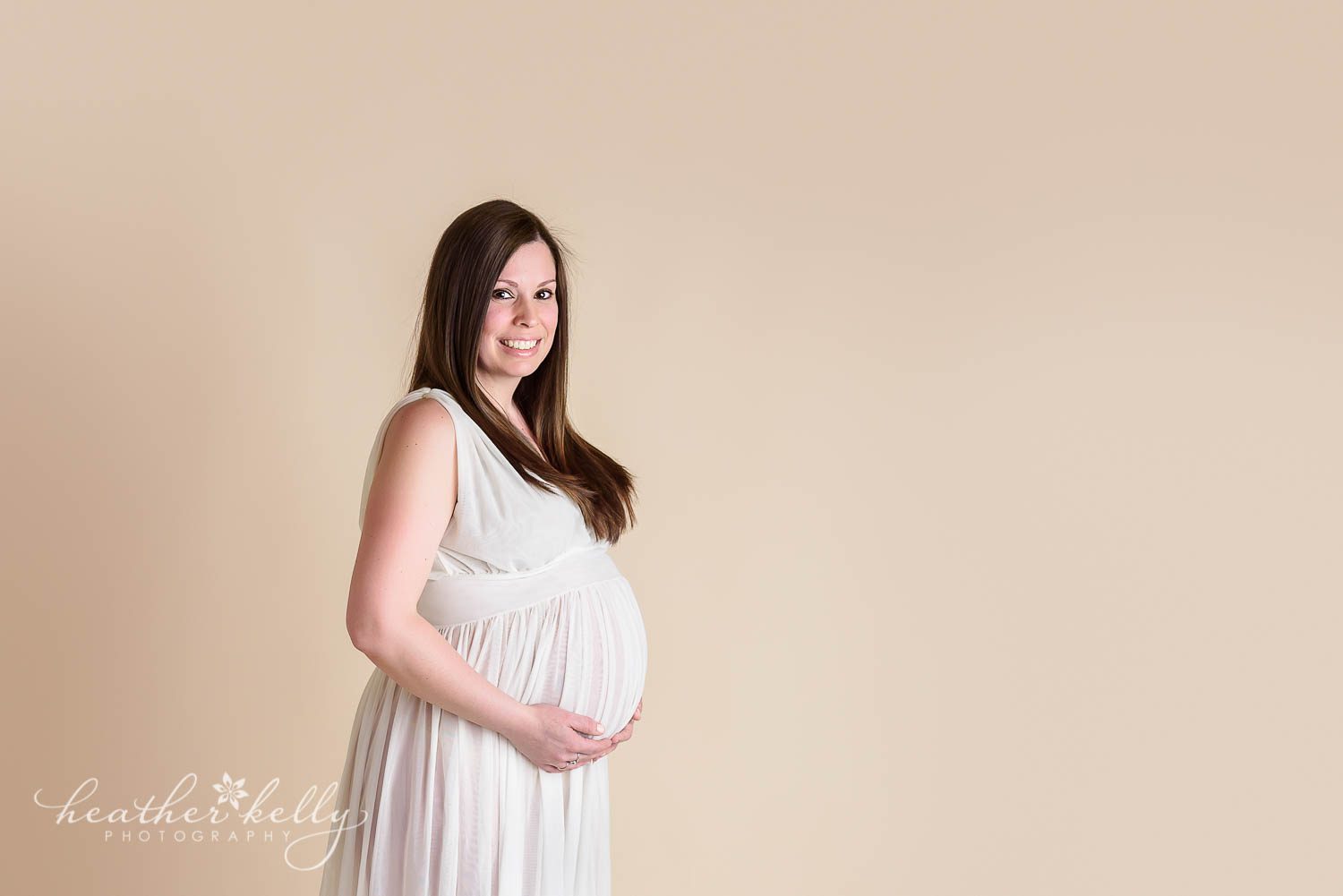 maternity photography of pregnant mom to be in white gown