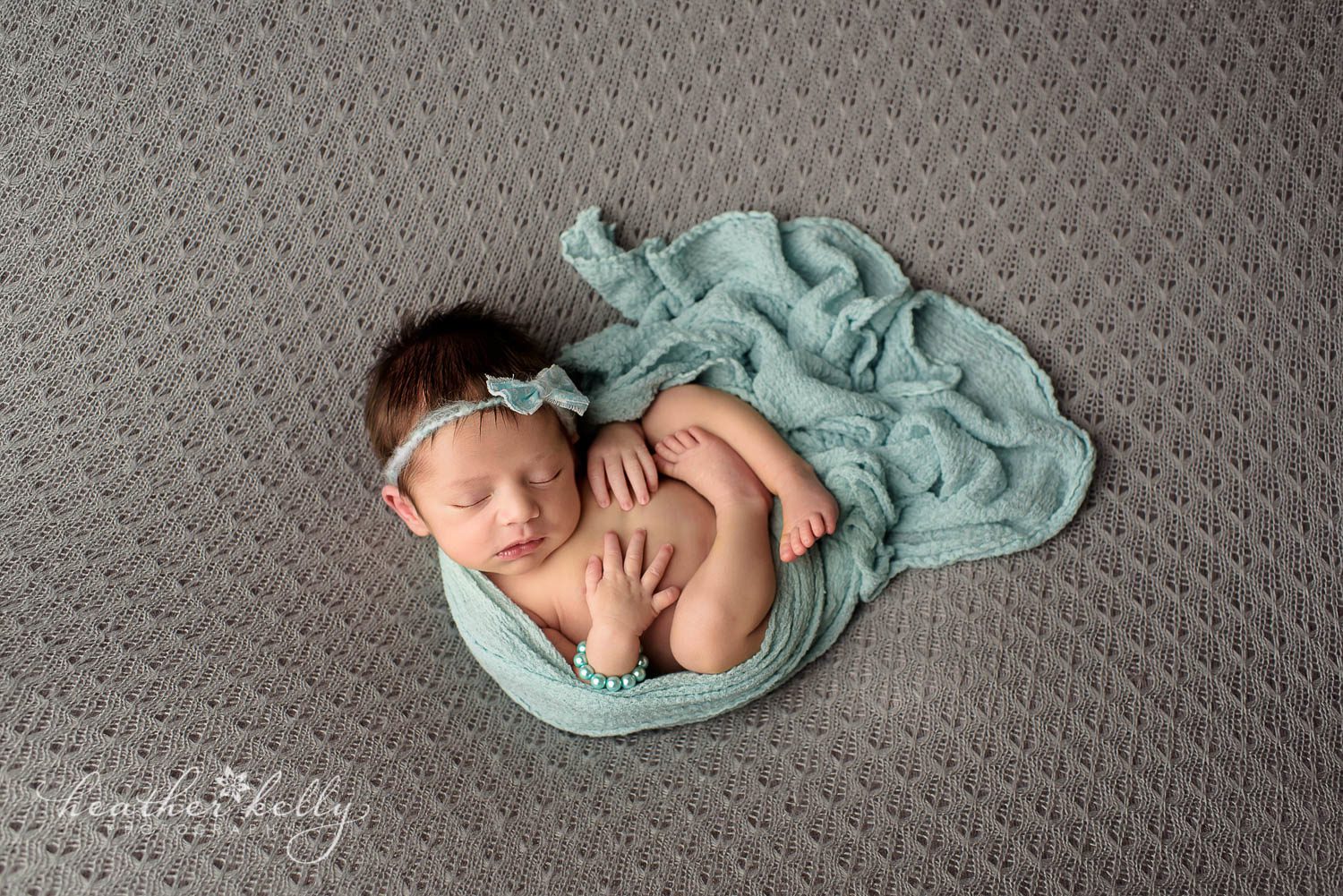newborn girl. newborn photography. baby girl on back with blue wrap. monroe ct newborn photography