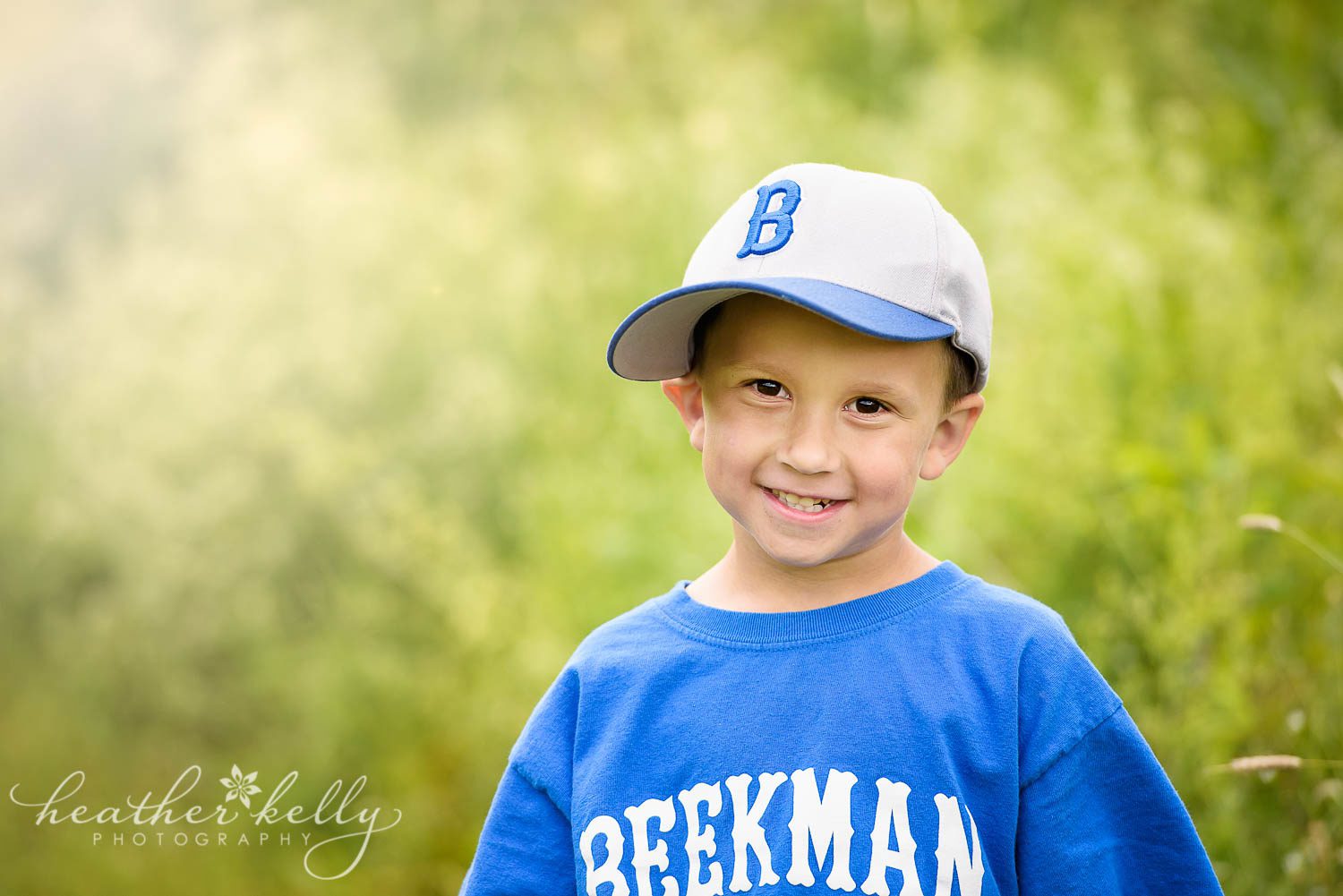 boy in baseball hat during photo session with tall grass in pretty light. poughquag ny family photography