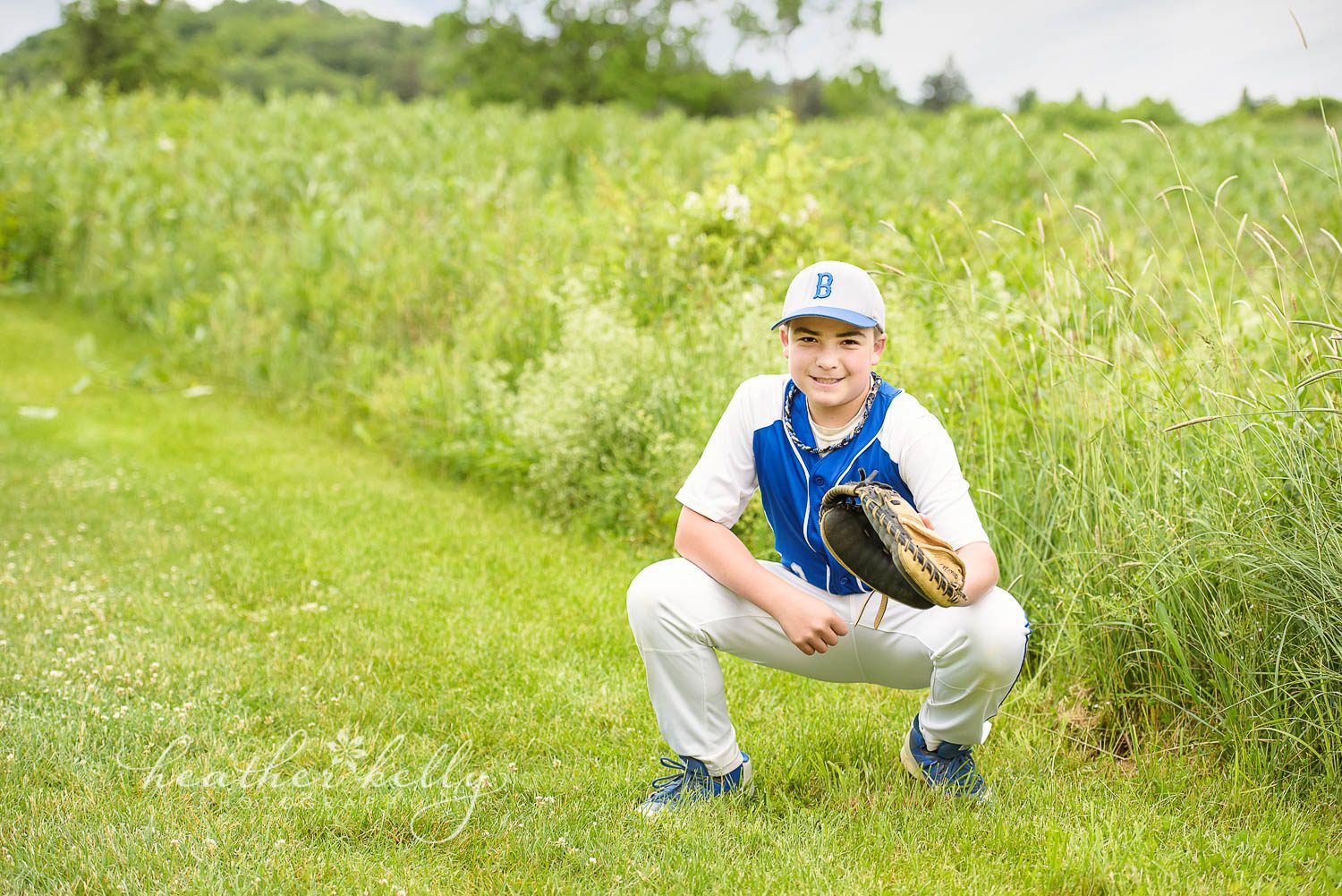 child squatting in baseball uniform. poughquag ny family photography. baseball session