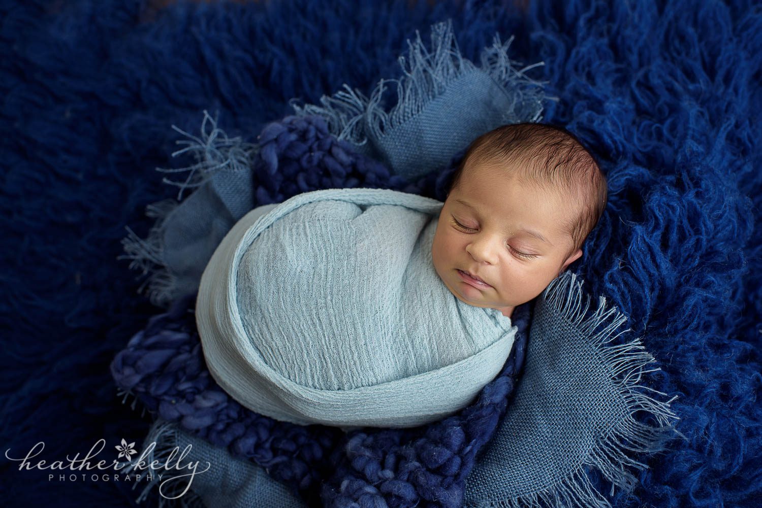 sleeping newborn wrapped in light blue. Newborn wrapping poses