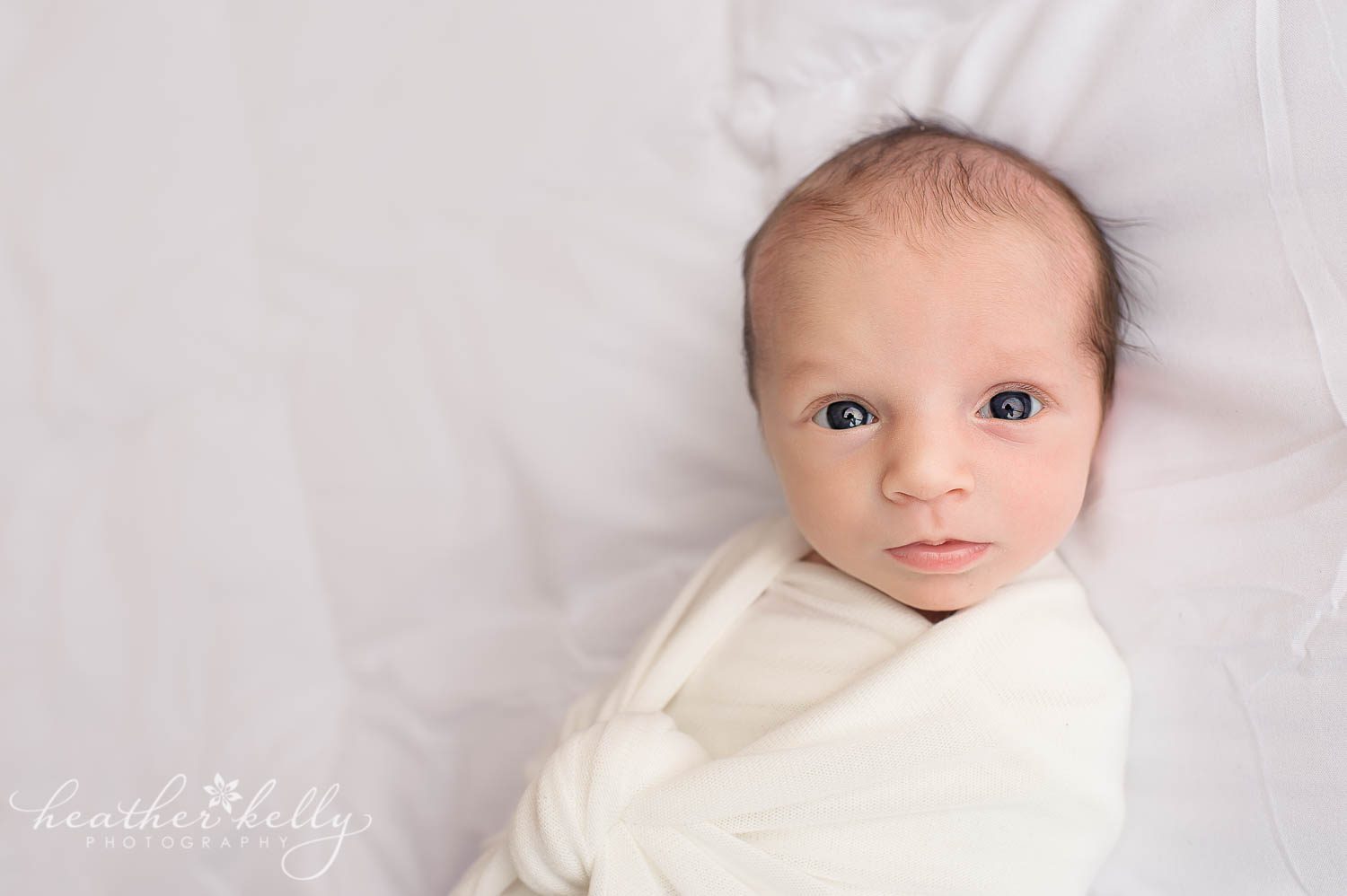 awake newborn wrapping poses. White on white newborn girl