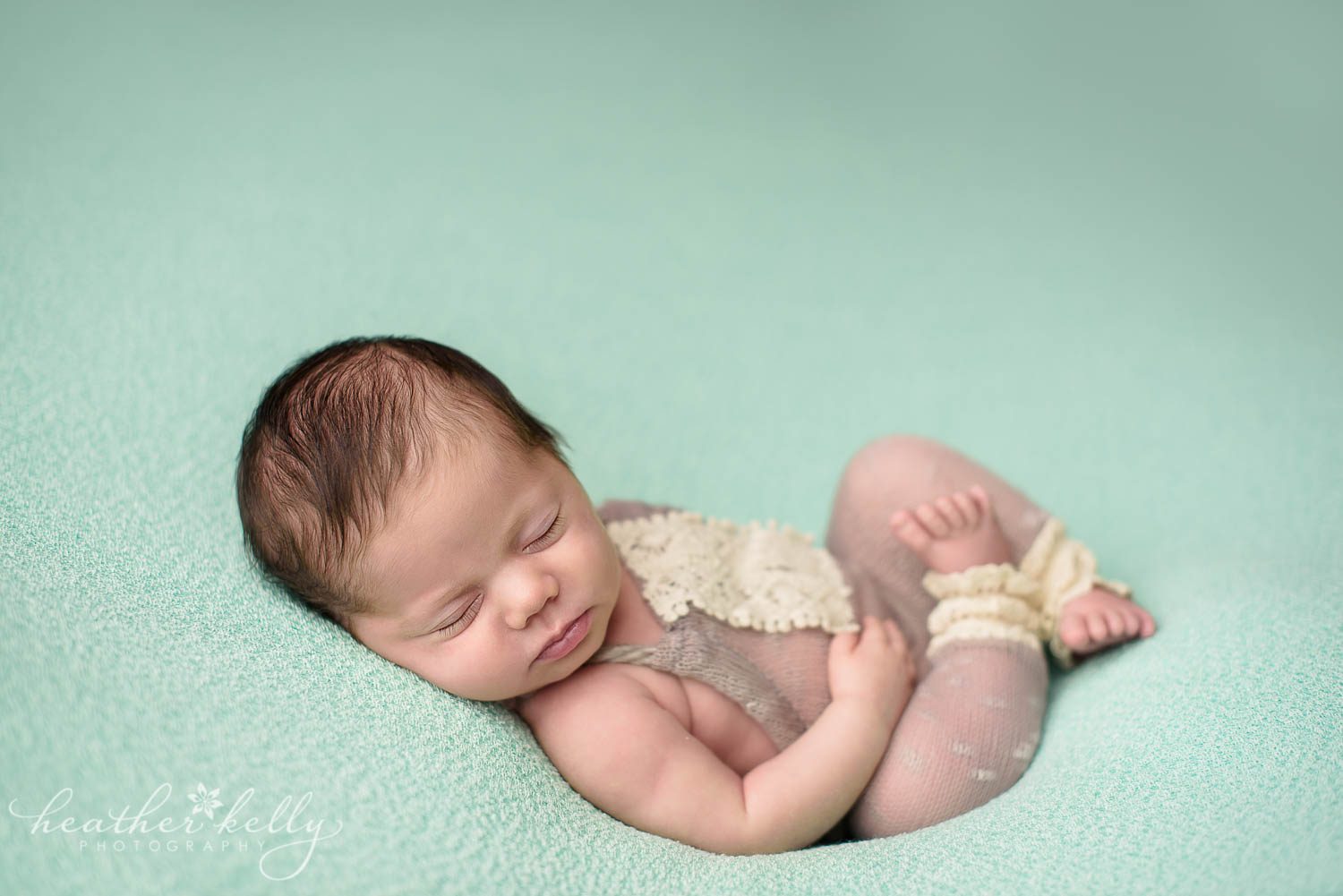 newborn photography poses. baby girl on back in outfit during newborn photography session