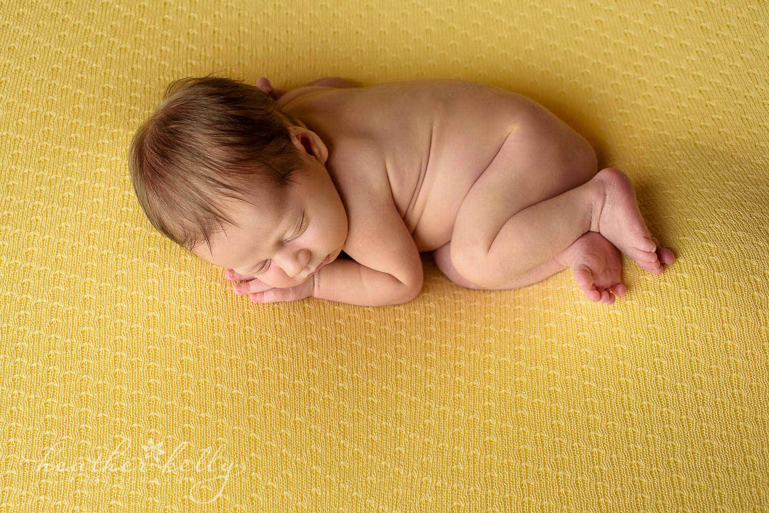 sleepy newborn boy on yellow