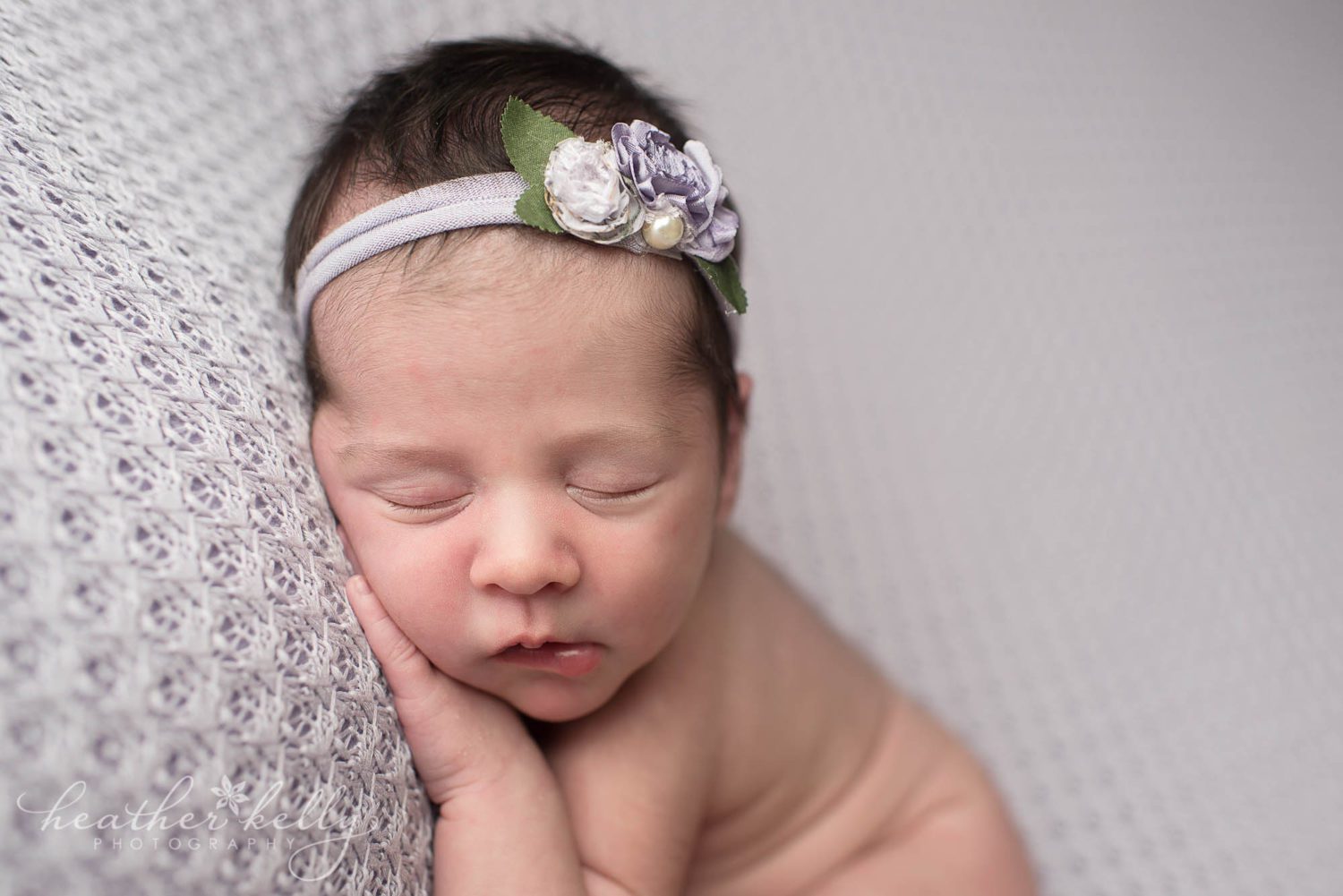 sleeping newborn girl in purple. 