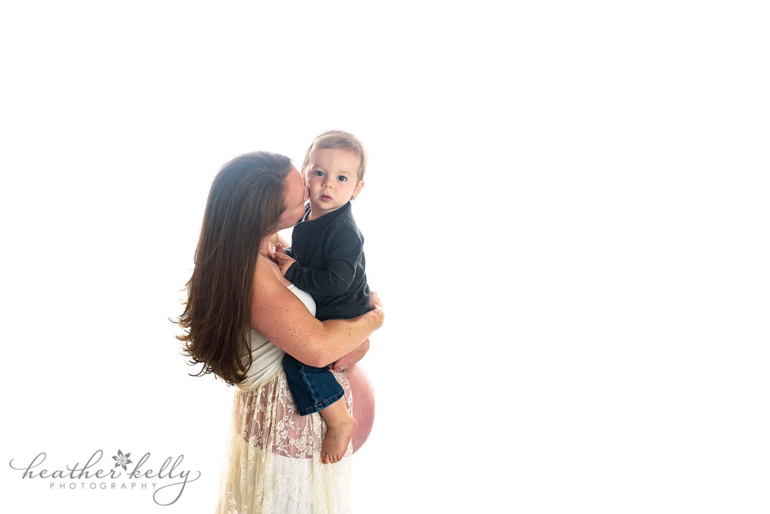 sandy hook maternity photography

35 week pregnant mom holding her 20 month old son and kissing him. He is looking at the camera. She is wearing a white lace maternity gown. 