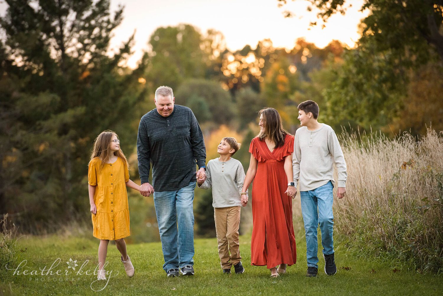 brookfield area family photography. Family of 5 at sunset holding hands and looking at each other.