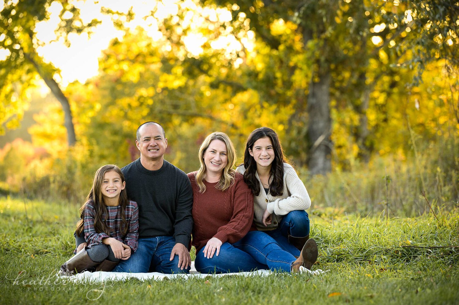 a family of four sits together on a blanket during their trumbull ct photography session